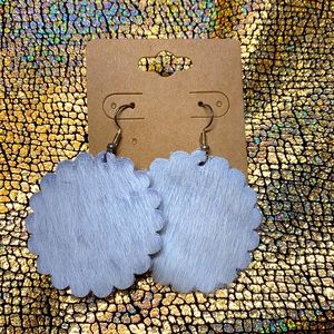 Hair on white scalloped earrings.